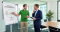 Therapeut an Whiteboard im Meetingraum mit Unternehmensmanager