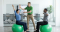 Therapeut mit 2 Angestellten auf Gymnastikball